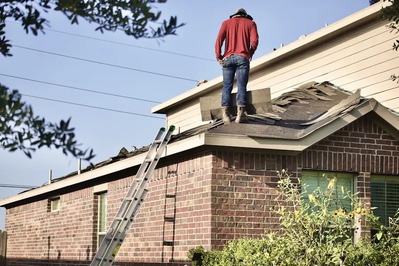 Professional roofer working on a residential roof in Harris